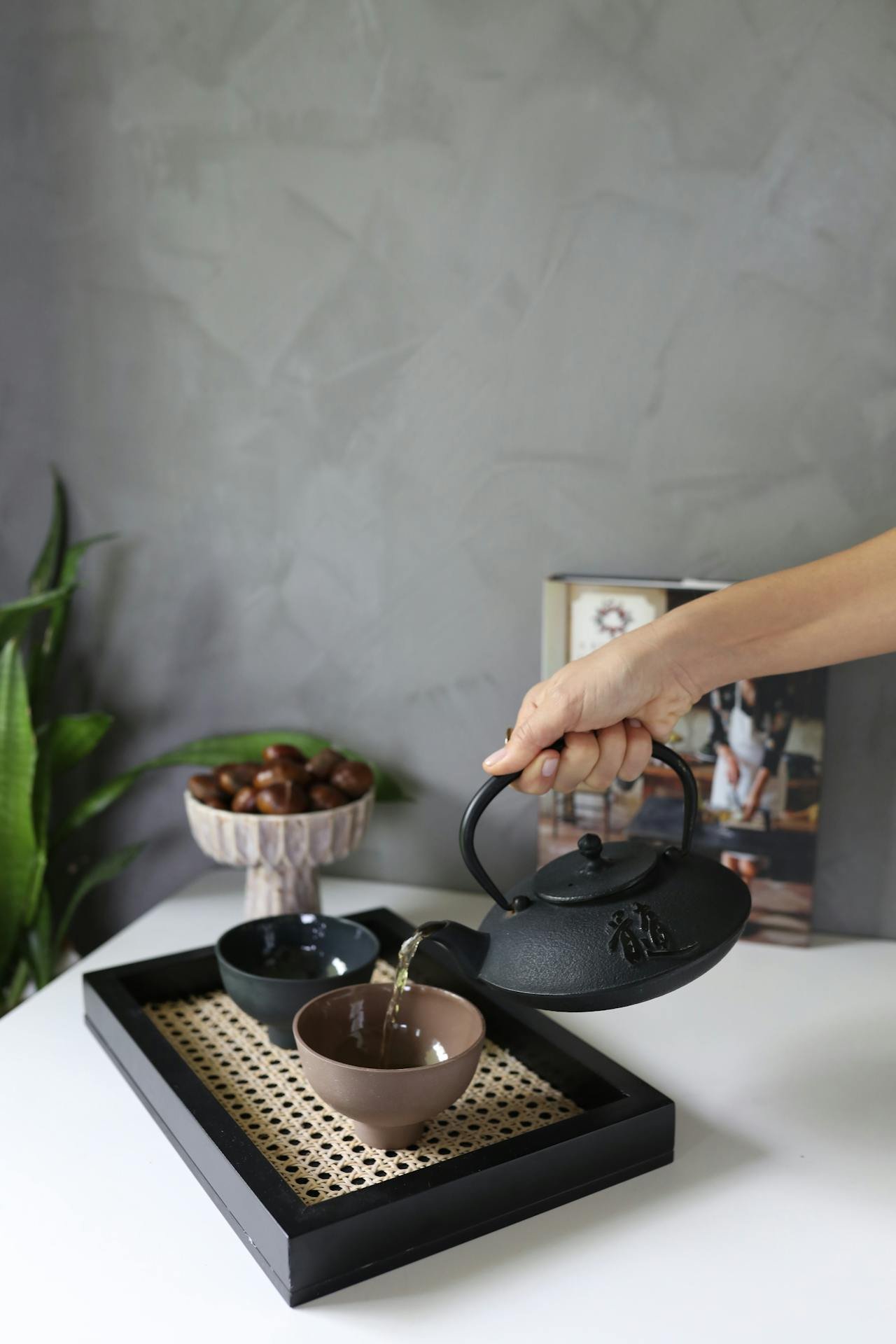 a person pouring water into a teapot